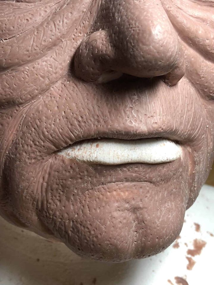 Close-up of sculpted wrinkles around the Emperor's mouth