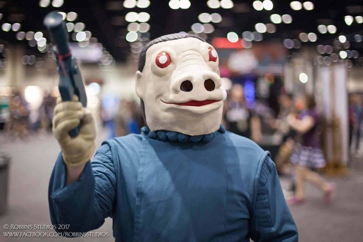 Snaggletooth cosplayer waving on the convention floor