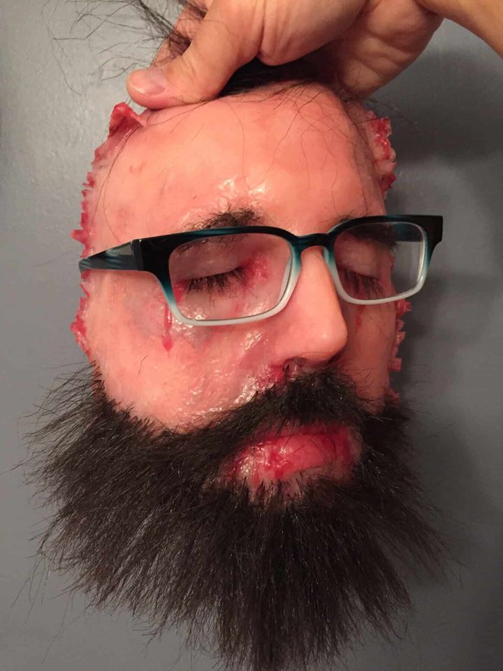 Client wearing glasses holding his silicone face
