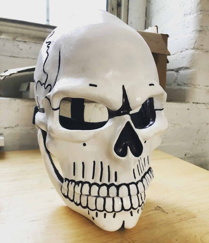 Finished Day of the Dead skull mask on a stand