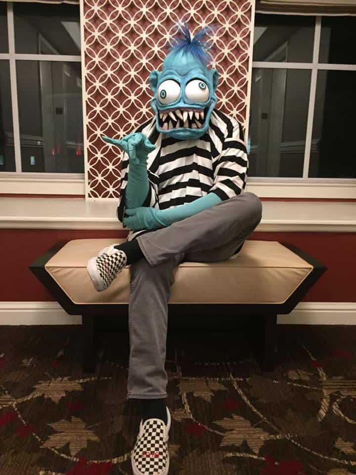 Weird-Oh masked cosplayer seated on a bench